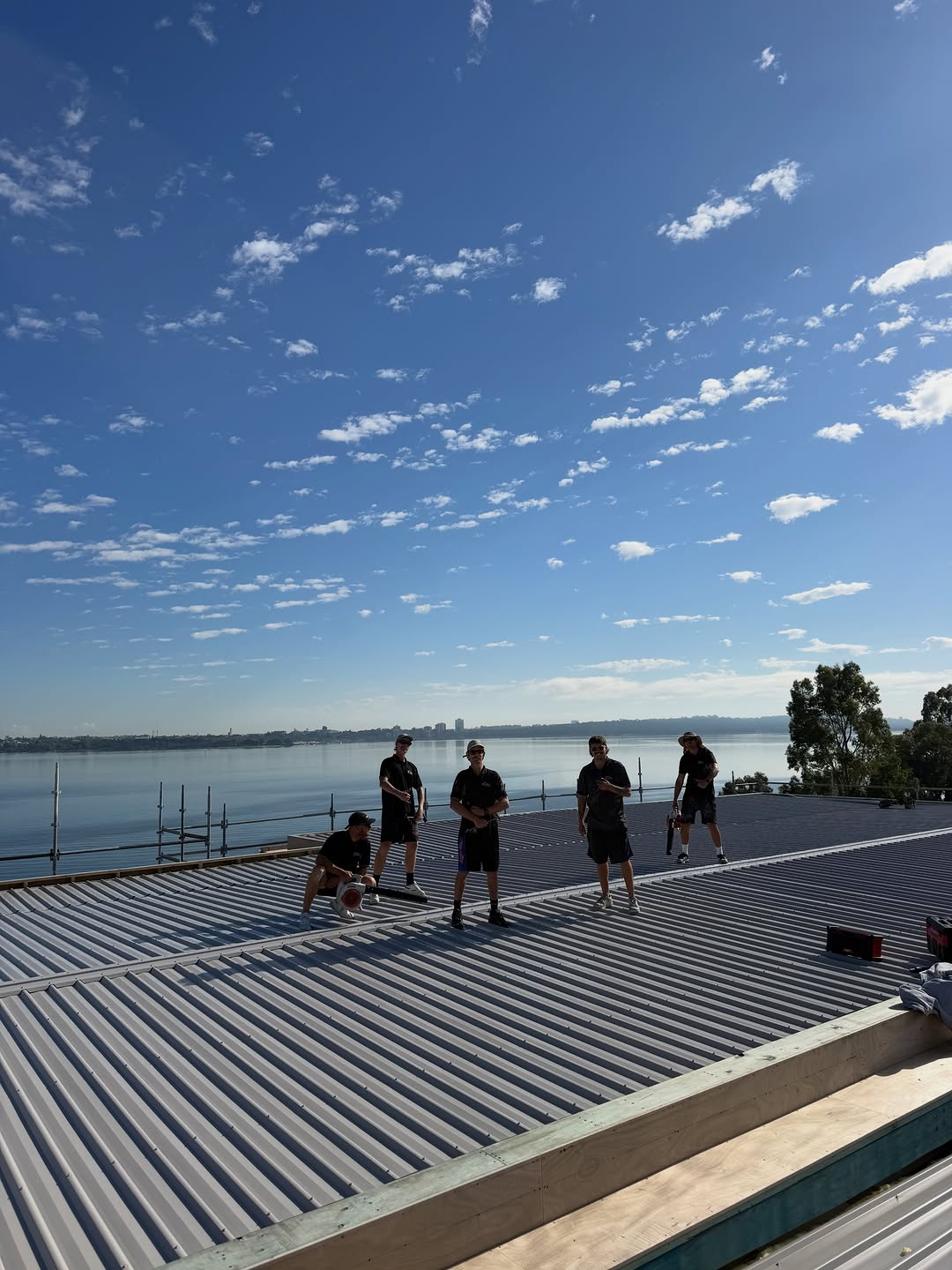 The McDonald Roofing crew on a finished roof, enjoying the view